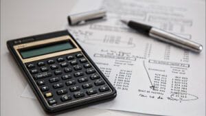 Una calculadora y unas hojas de cálculo de un presupuesto personal