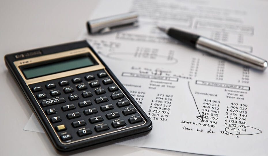 Una calculadora y unas hojas de cálculo de un presupuesto personal